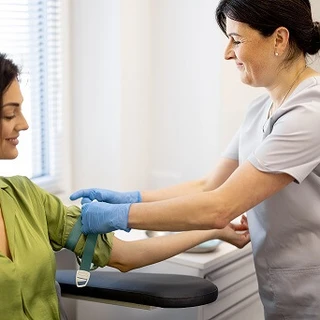 Pielęgniarka przygotowuje kobietę do pobrania krwi