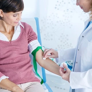 Pielęgniarka przygotowuje kobietę do pobrania krwi