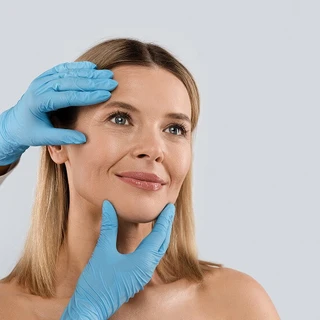 Kobieta jest badana przez lekarza przed zabiegiem liftingu twarzy