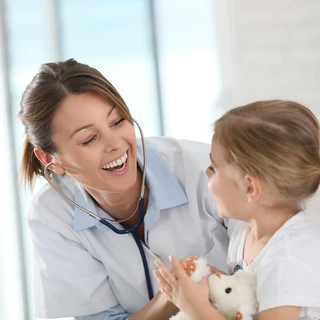 Lekarz osłuchuje stetoskopem dziewczynkę