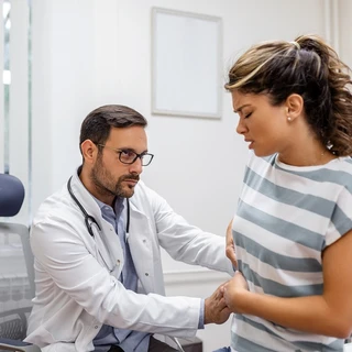 Lekarz bada kobietę w gabinecie lekarskim