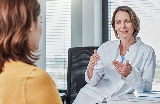 lekarka tłumaczy kobiecie szczegóły zabiegu w gabinecie lekarskim